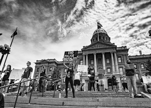 Photo of a government building with protesters in front of it