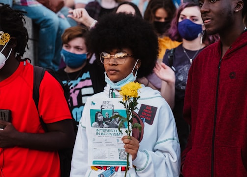 A women holding a rose and a protest sign