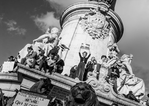 Protestors standing on a statue